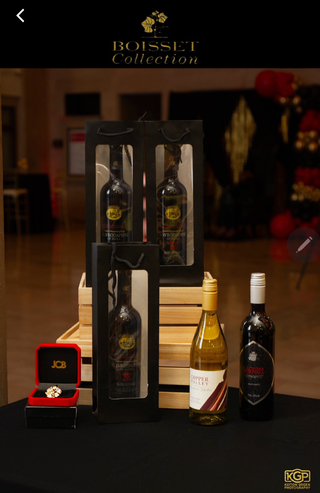 A photorealistic image capturing the spirit of P Live’s mission in the wine business and event management. The scene depicts a lively wine event in a beautifully decorated venue, with guests mingling, tasting various wines, and enjoying curated culinary pairings. Warm, ambient lighting creates a welcoming atmosphere, complemented by decorative elements like grapevines and elegant table settings. The color palette features luxurious golds and deep violets. The camera angle is dynamic, showing interactions among guests and the ambiance of the event. Textures of the food, glassware, and decorations are highly detailed. Technical specs: 4K resolution, high quality.